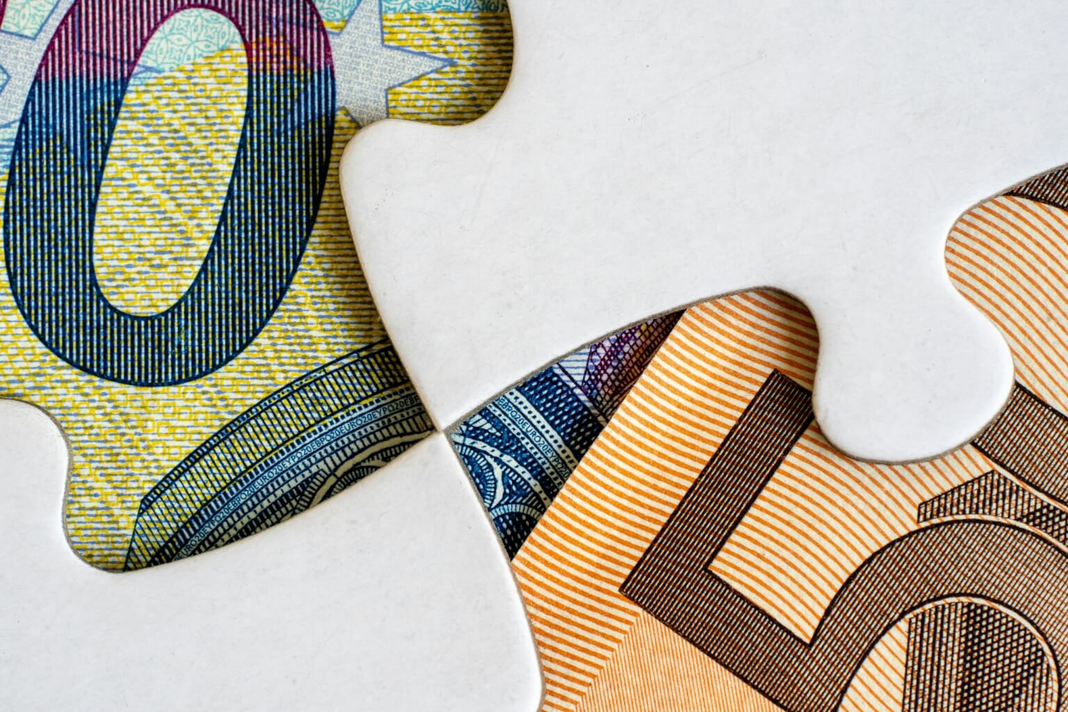 Jigsaw pieces with euro banknotes, symbolising complete financial solutions.