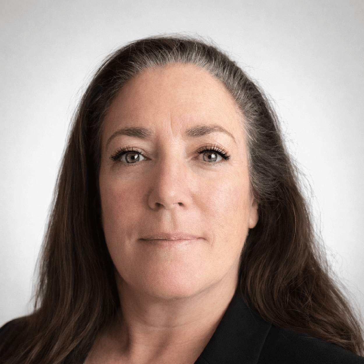 Portrait of a middle-aged businesswoman with long brown hair and a professional smile, suitable for a corporate or consultancy profile.