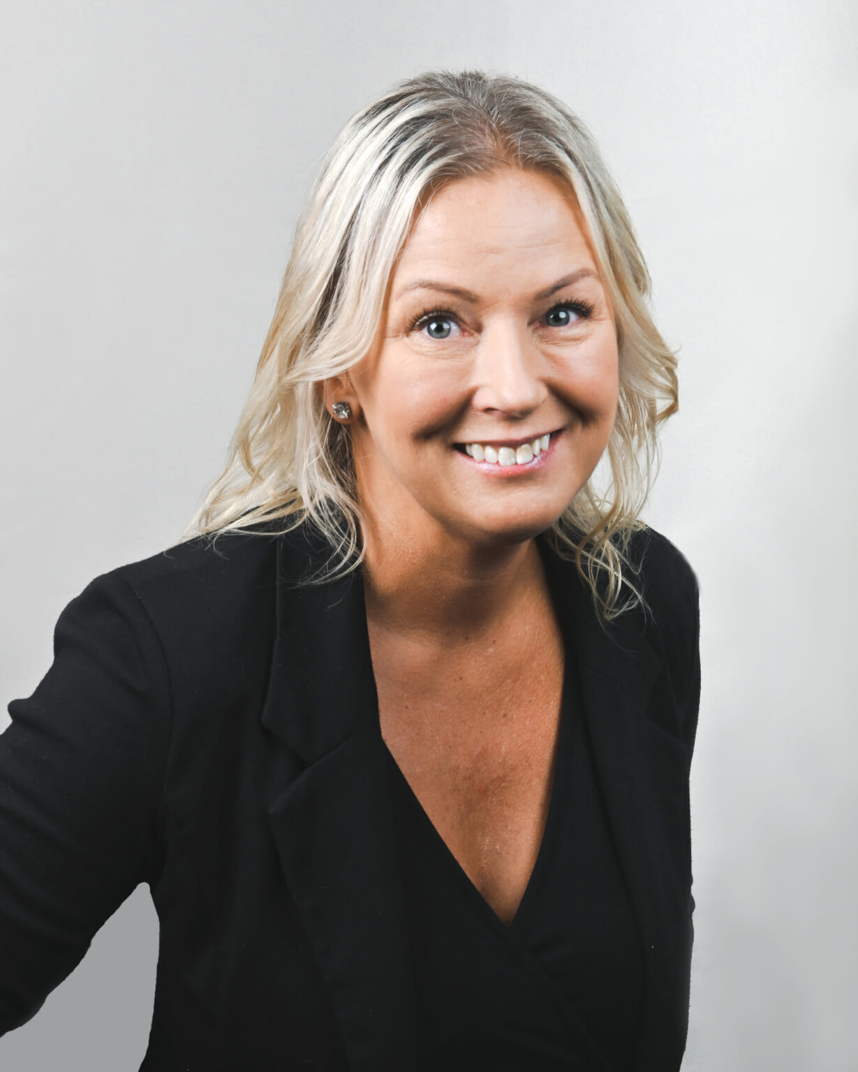 Smiling businesswoman in a black blazer, professional portrait.
