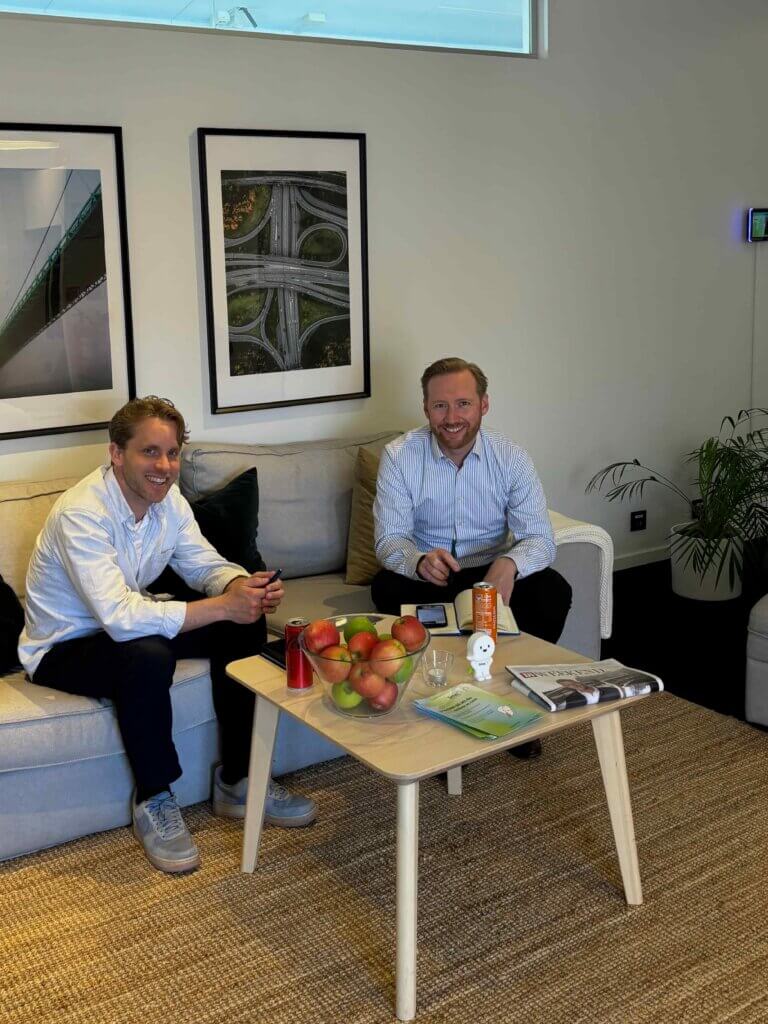 Two consultants discussing CRM solutions in a comfortable office setting, surrounded by modern decor and refreshments.