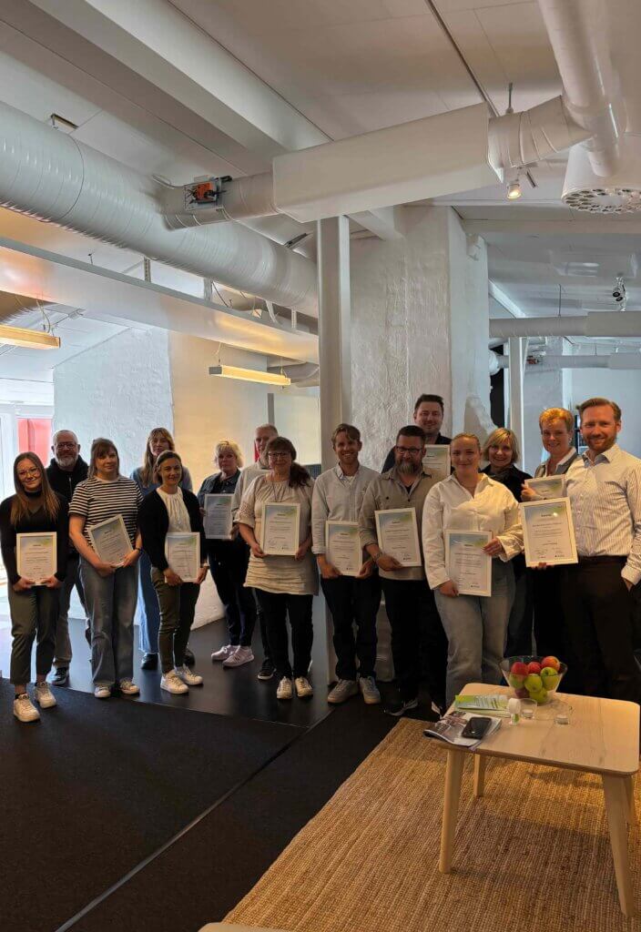 A team of professionals holding certificates in a modern office environment, showcasing successful CRM implementation across various industries including consultancy and real-estate.